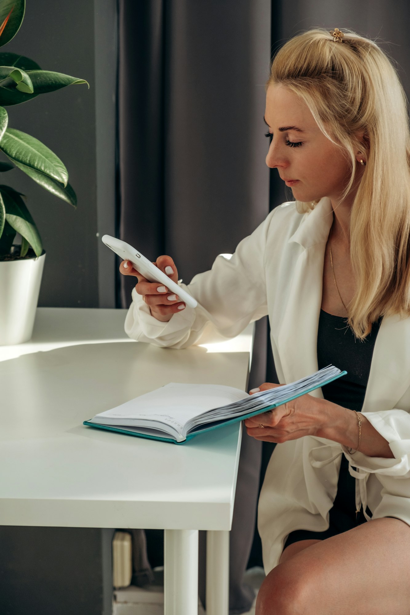 A young blonde business woman uses a smartphone.