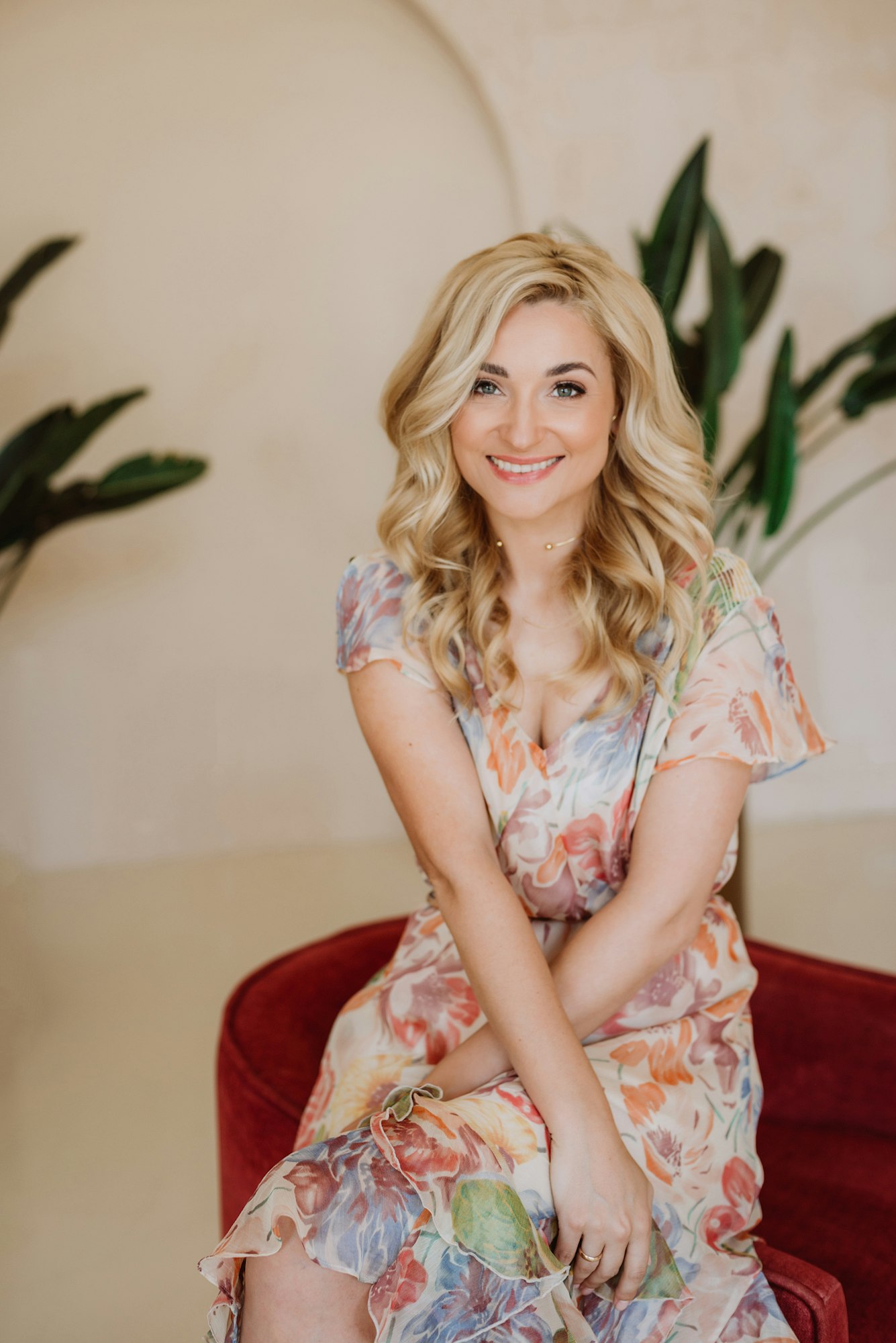 Beautiful happy blonde woman with a sincere smile in a summer dress with a floral print.